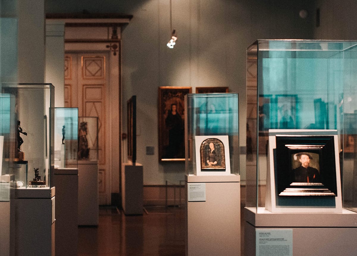 Photo of a museum exhibit with various artworks displayed in glass cases.