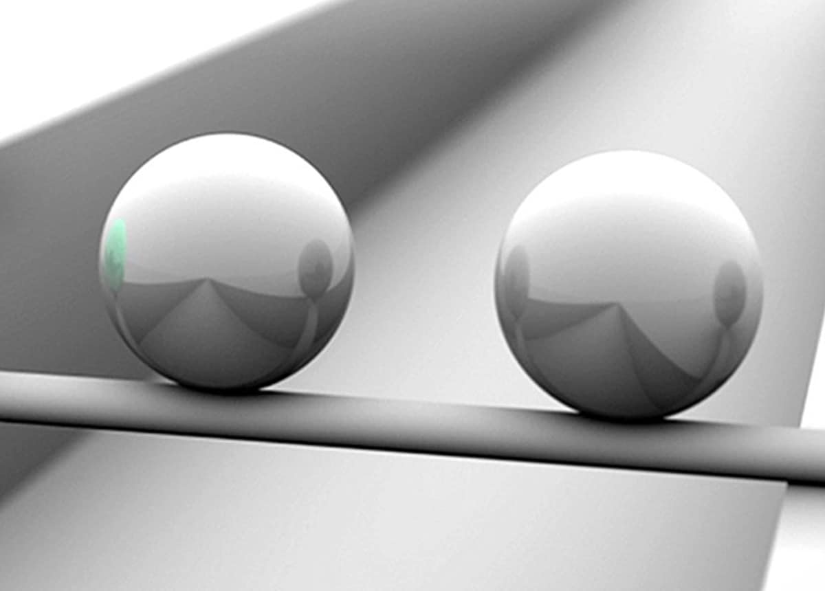 Image of two metal spheres on a reflective surface, used to illustrate persuasion techniques.