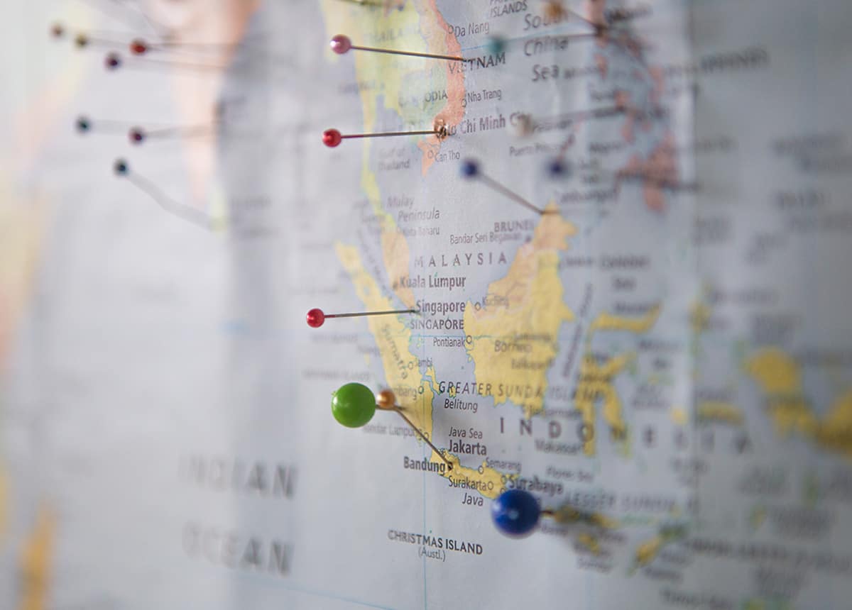 Close-up of a world map with pins marking locations across Southeast Asia.