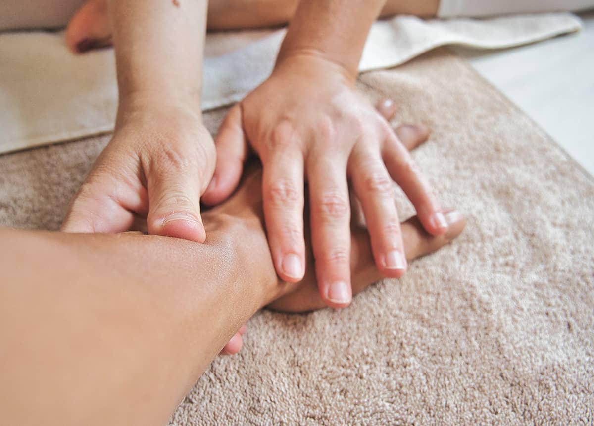 Close-up of hands performing a massage on a person's arm.